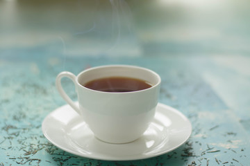 A cup of hot tea with different colours background.