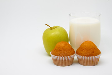 Glass of milk, piece of fruit (Apple) and cupcakes. Healthy eating concept for breakfast and a good start to the day
