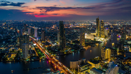 Fototapeta premium Widok z lotu ptaka na panoramę Bangkoku i wieżowiec z BTS Skytrain centrum Bangkoku. Panorama dzielnicy biznesowej Sathorn i Silom Bangkok Tajlandia o zachodzie słońca.