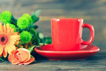 Cup of coffee and bunch of flowers