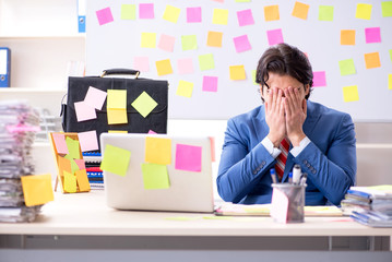 Young male handsome employee in conflicting priorities concept 