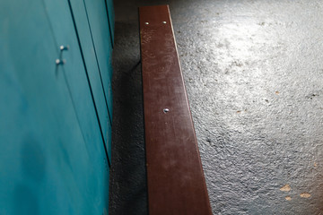 Green metal lockers with a wood bench in a sport locker room