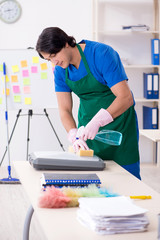 Male handsome professional cleaner working in the office 