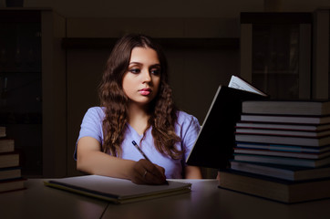 Young female student preparing for exams late at home 