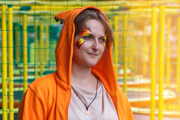 Woman in a Fox costume on the background of trampolines. The girl in the hood with ears squirrels....