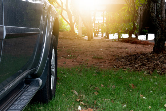 Side Of The Gray Car That Is Parked In The Shade Of Tree. Resting Place. With Orange Light.