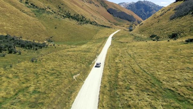Cinematic aerial drone footage driving through beautiful landscapes with mountains and lakes in the background on the way to lake moke queenstown new zealand glenorchy road
