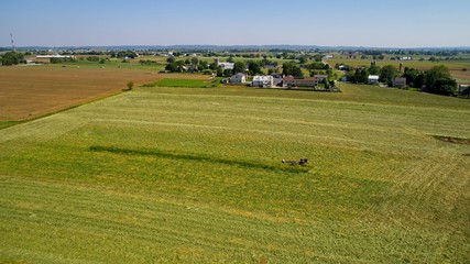 Fototapeta na wymiar Aerial View of Amish Farmers Harvesting there Crops in Summer