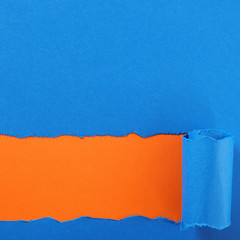 Torn blue paper strip orange background