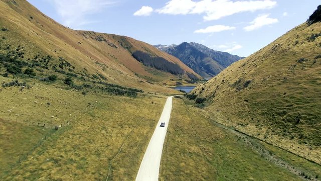 Cinematic 4k aerial drone footage driving toward lake moke through beautiful landscapes with mountains and lakes in the background in queenstown new zealand glenorchy road