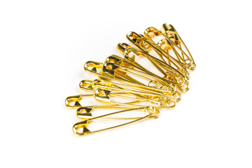 Stack of gold colored safety pins on a white background