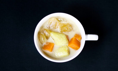 Indonesian sweet desserts or kolak on black background. 
