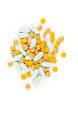Scattered green and yellow pills over a white background