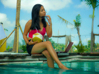 young beautiful and happy Asian Indonesian teenager woman in bikini at tropical resort swimming...