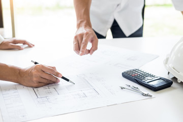 Close-up Of Person's engineer Hand Drawing Plan On Blue Print with architect equipment, Architects discussing at the table, team work and work flow construction concept