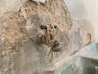 Llave de bronce tipo jardín con ligas alrededor por fuga de agua.
