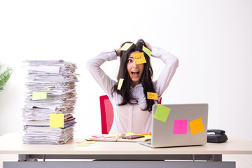 Young female employee in conflicting priorities concept 