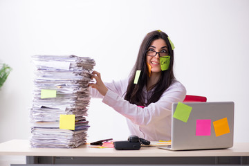 Young female employee in conflicting priorities concept 