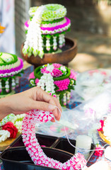 Thai woman making a tradition Thai flowers garland activities in Songkran festival, Bangkok Thailand.
