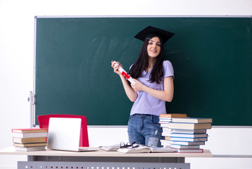 Female graduate student in front of green board 