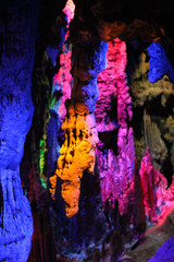 beautiful illuminated multicolored stalactites from karst Reed Flute cave In the cave. Guilin Guangxi China