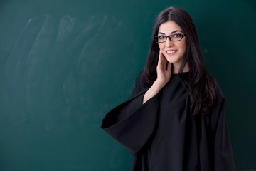 Female graduate student in front of green board 