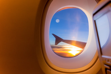 Beautiful scenic of sunrise and fullmoon through the aircraft window.