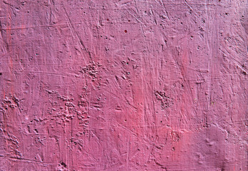 Blurred abstract background. Texture painted rough concrete surface with cracks and holes pink. Cropped shot, horizontal, place for text, nobody. The concept of repair and design.