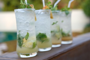 pineapple mojito cocktail and lime mojito cocktail at swim pool background