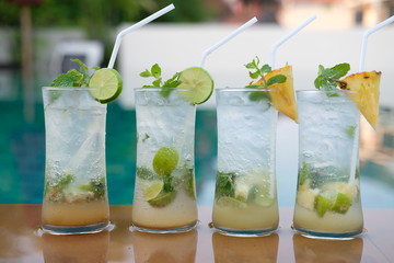 pineapple mojito cocktail and lime mojito cocktail at swim pool background
