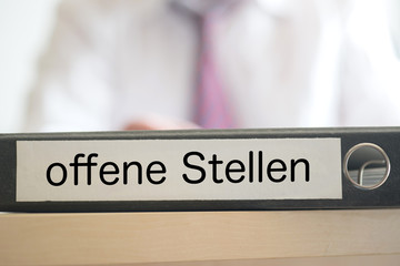 Ein Mann und ein Ordner mit dem Aufdruck Offene Stellen