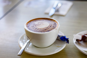 Cup of cappuccino on a table, close up.