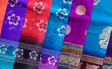 Closeup view of Indian woman fashion sarees or saris hung in display of a retail shop