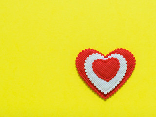 Bright red and white heart on yellow background. The view from the top. Flat lay.