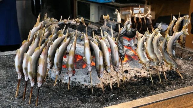 Fish Ayu with salt being charcoal broiled in Japanese grilled fish style , Ayu  is famous fish and traditional Japanese cooking style ,Many Ayu fish surrounding  of charcoal broiled in Japan.