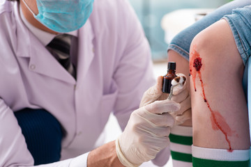 Leg injured young woman visiting male doctor 