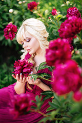 Outdoor close up portrait of beautiful young woman in the blooming garden. Female spring fashion concept