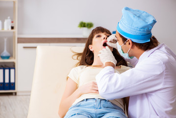 Obraz na płótnie Canvas Young woman visting male doctor otolaryngologist