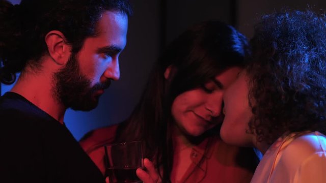 Three people flirting sensually in a club.love triangle, polyamory