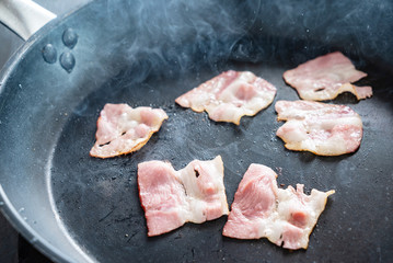 slices of fresh fried bacon in a pan for breakfast