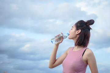 Asian woman drinking water from water.