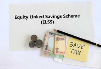 Equity linked savings scheme, elss, an Indian tax saving investment option, concept highlighted through text, Indian rupees in an envelope, coins and handwritten save-tax note.