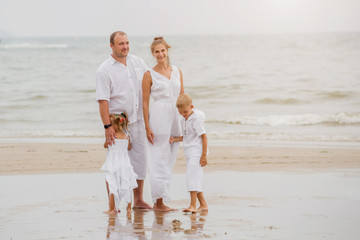 Happy young family on the sunset at the beach.