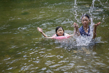 Family Asian Mother and daughter Play Water in the river