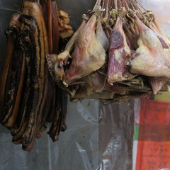 Smoked chicken pieces and bacon hang out in Hong Kong outside at a shop on the street