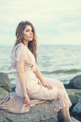 Fototapeta na wymiar Attractive woman in boho dress on ocean coast, romantic portrait