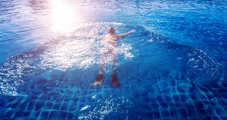 Young athletic man swimming in the swimming pool