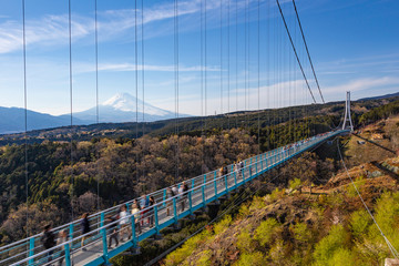 People walkin on Mishima Skywalk bridge with Mount fuji seen in the distant, clear sunny day