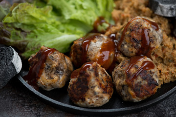 Roasted truffles made of mushrooms and cheese and topped with sauce, close-up, selective focus