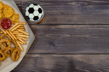 Diverse snacks with beer on dark wooden background. Top view, Empty space for text